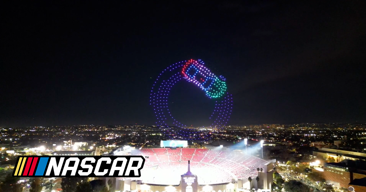 A NASCAR Car racing around track in the sky during drone show
