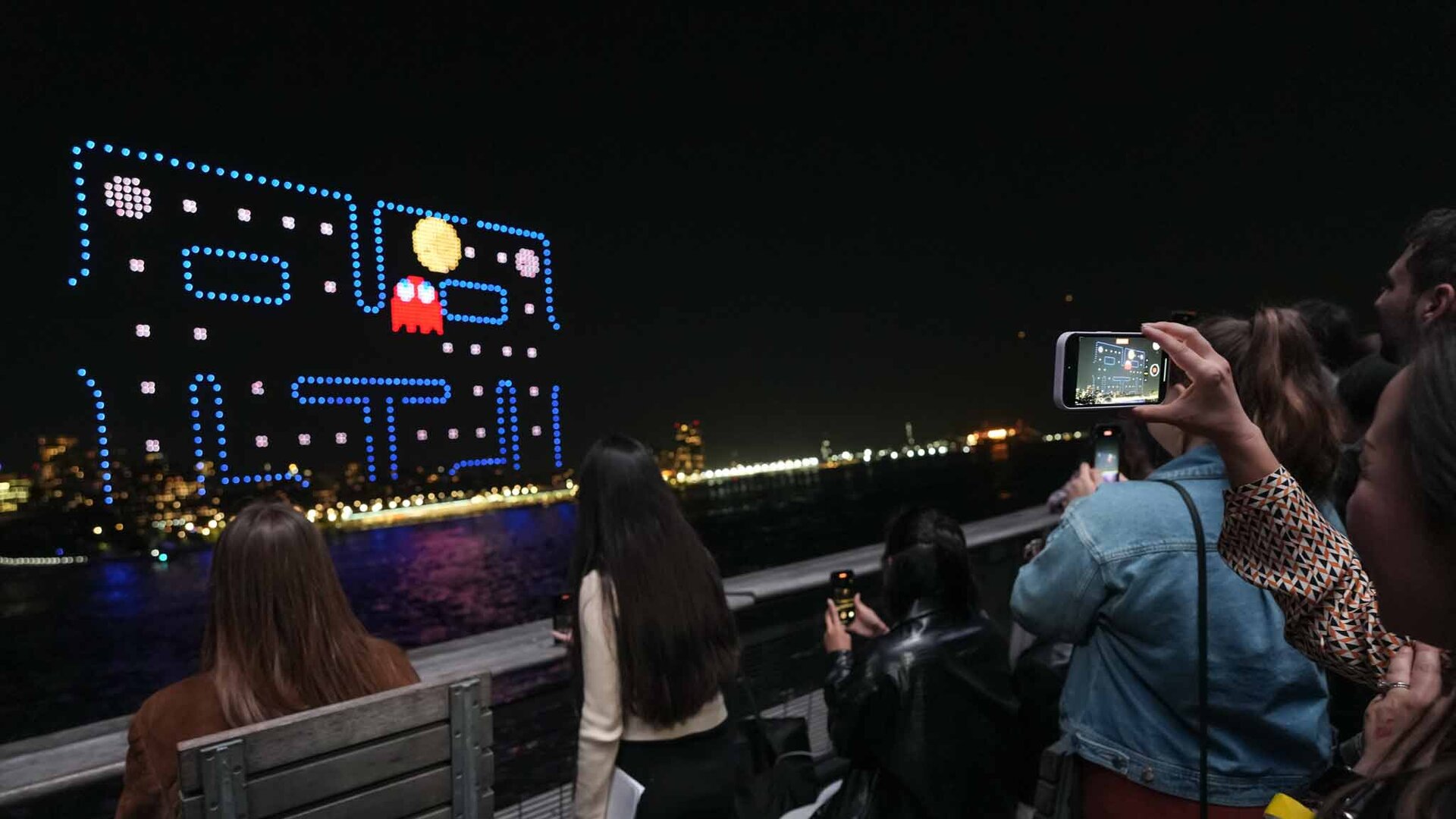 People filming gameboard in the sky at pac-man at the Shine On drone light show