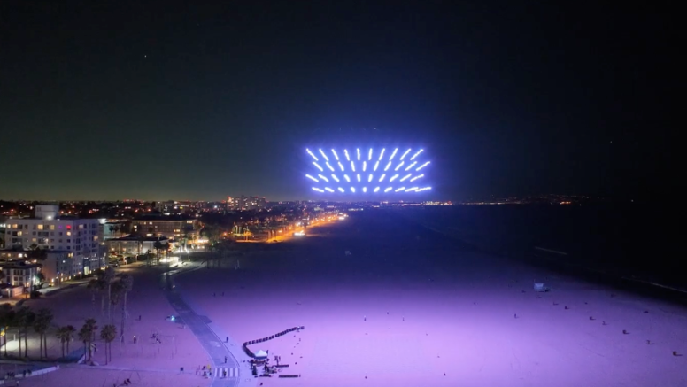 A swarm of drones in a light show rising over the beach in Santa Monica