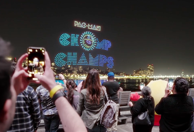 Person filming Pac-Man gameboard in drone light show