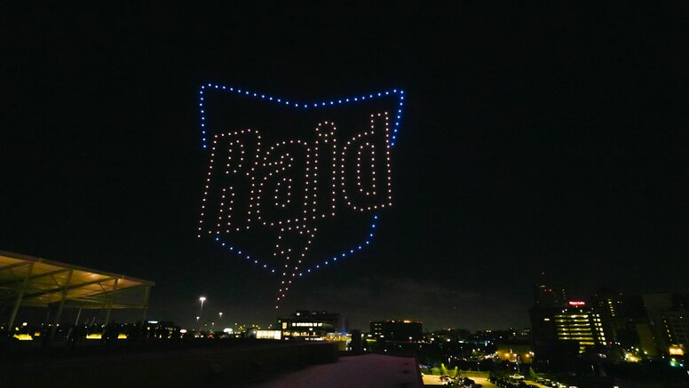 Raid logo in sky over Houston during drone light show