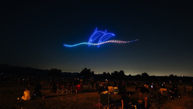 Dolphins swimming in sky at Pixis drone light show in LA area