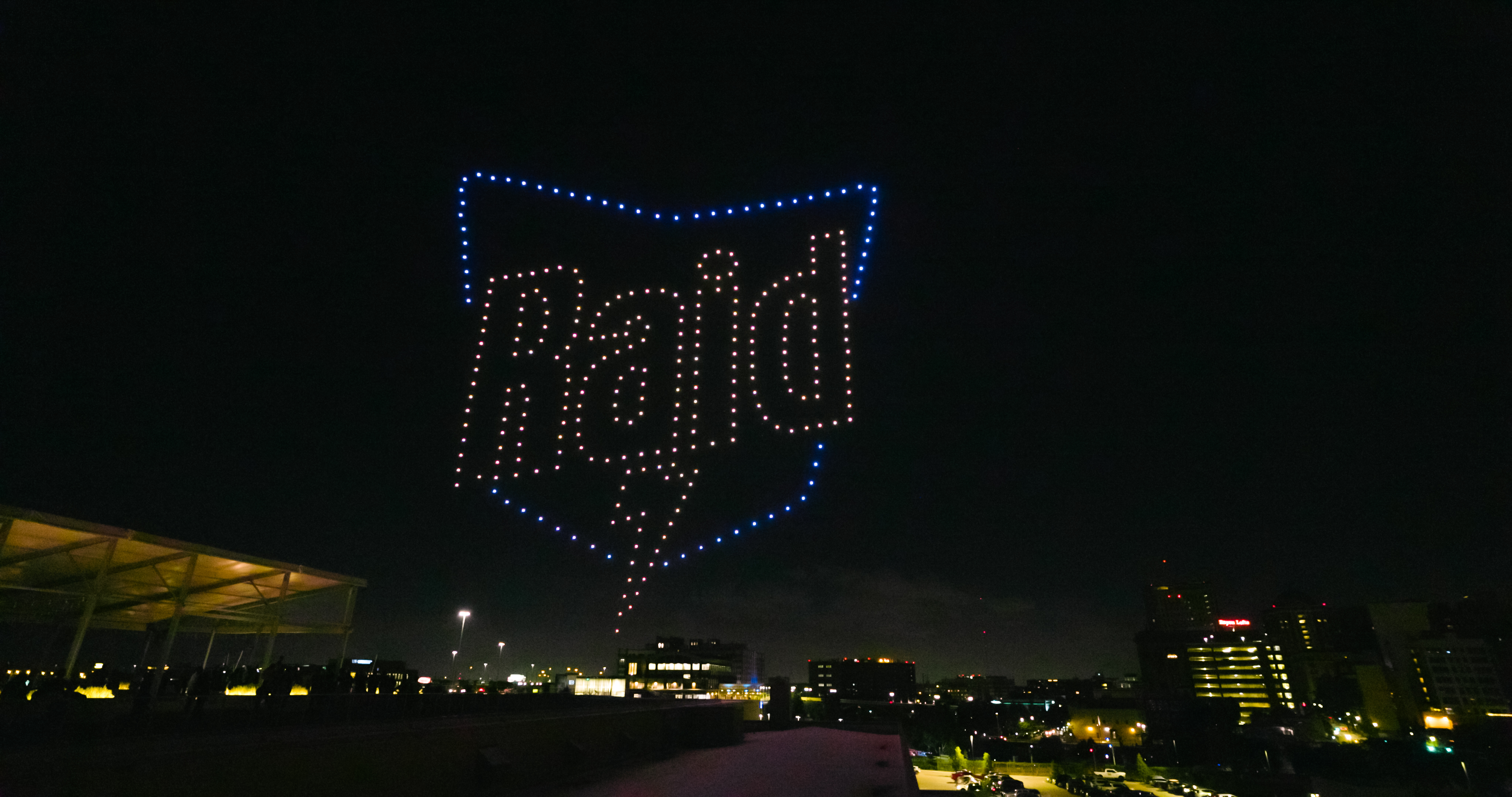 Raid logo in sky over Houston during drone light show